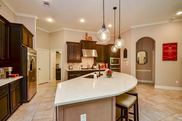 a kitchen with sink a refrigerator and chairs