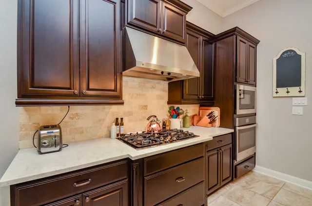 a kitchen with stainless steel appliances granite countertop a sink stove and cabinets