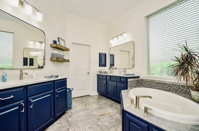 a bathroom with a granite countertop tub sink double vanity granite and mirror