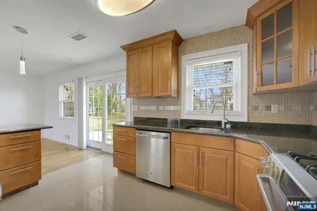 a kitchen with granite countertop a sink stove and cabinets