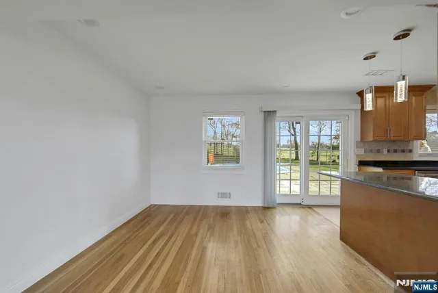 a view of a kitchen with wooden floor and a window
