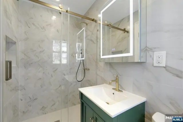 a bathroom with a sink mirror and a shower