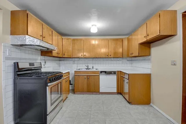 a kitchen with stainless steel appliances granite countertop a stove a sink and a microwave