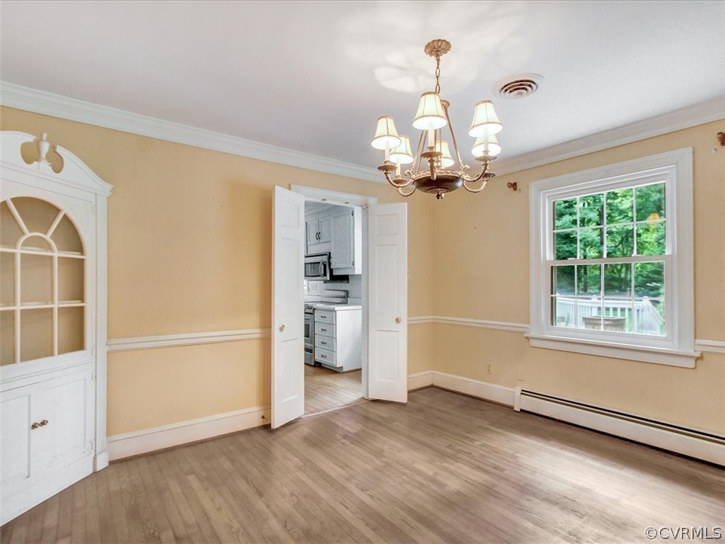 10231 Cherokee Road Richmond, VA 23235 - Photo 7 of 39 an empty room with wooden floor cabinet and windows