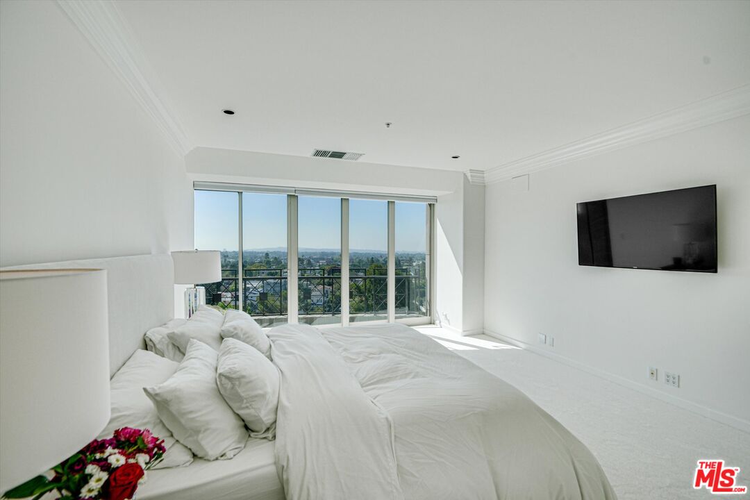 10580 Wilshire Boulevard, Unit 8SW Los Angeles, CA 90024 - Photo 11 of 38 a bedroom with furniture and a flat screen tv