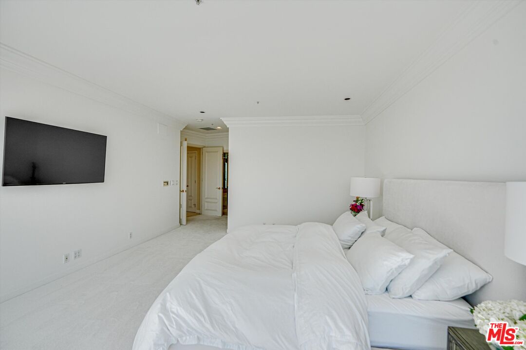 10580 Wilshire Boulevard, Unit 8SW Los Angeles, CA 90024 - Photo 13 of 38 a bedroom with a bed and a flat screen tv