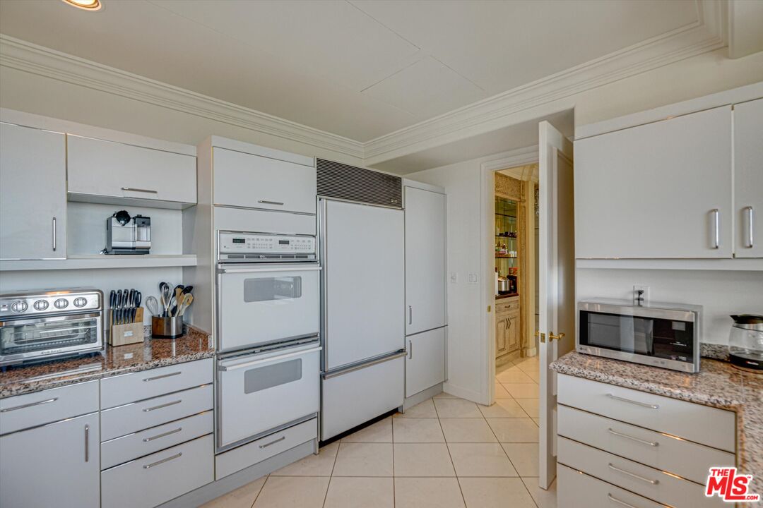 10580 Wilshire Boulevard, Unit 8SW Los Angeles, CA 90024 - Photo 27 of 38 a kitchen with white cabinets and white appliances