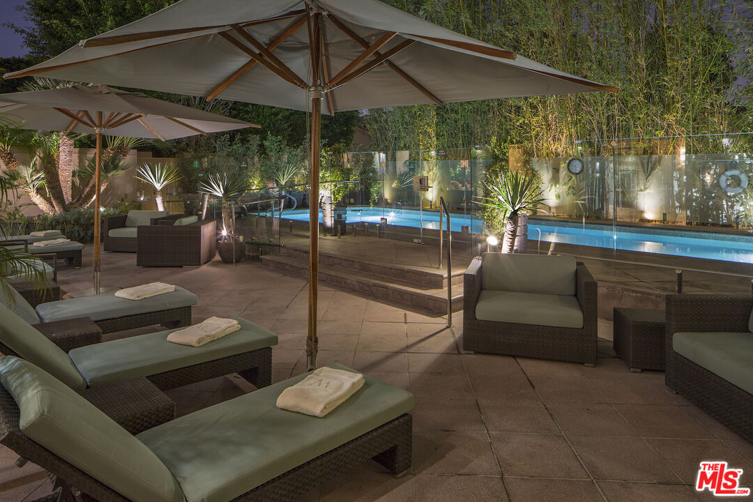 10580 Wilshire Boulevard, Unit 8SW Los Angeles, CA 90024 - Photo 29 of 38 a view of a patio with couches and table and chairs under an umbrella