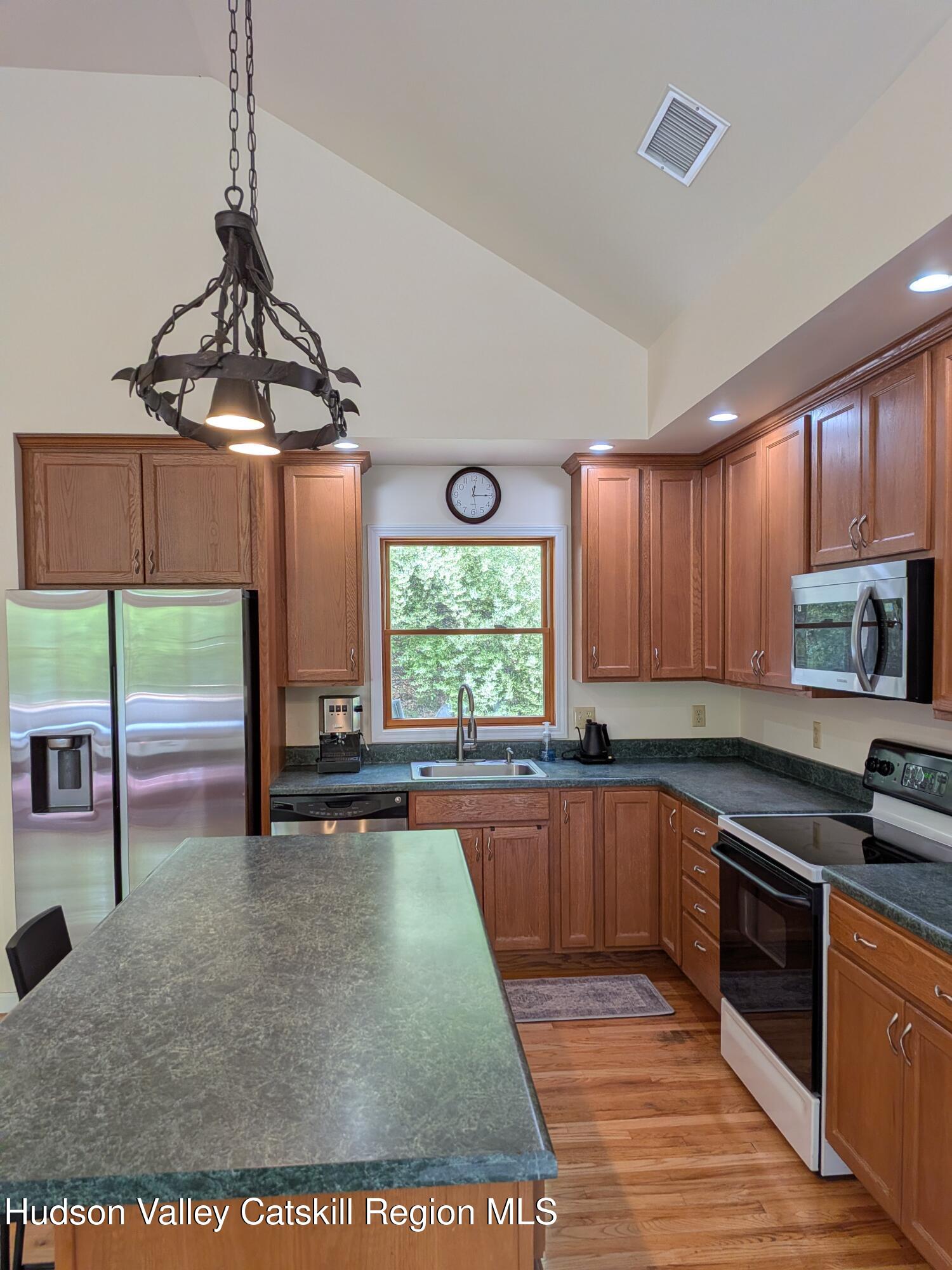 513 South Mountain Road Gardiner, NY 12525 - Photo 13 of 63 a kitchen with stainless steel appliances wooden cabinets a sink and a window