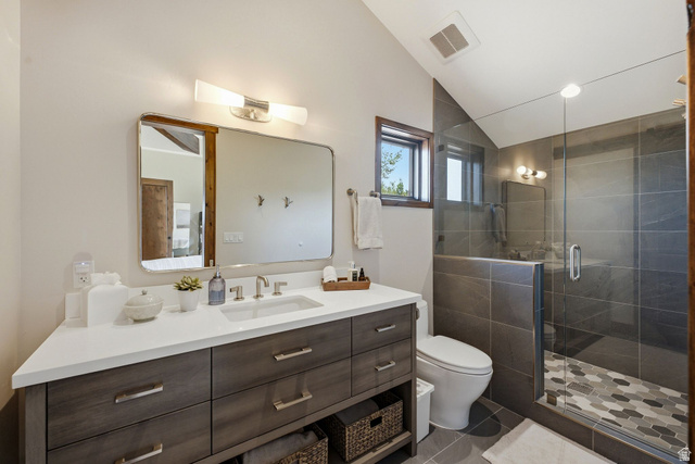 7885 North Rabbitbrush Court, Unit 13 Park City, UT 84098 - Photo 66 of 88 Bathroom featuring a wood-finish vanity with a white countertop, an integrated sink, a large wall mirror, and a glass-enclosed shower with dark gray tile walls and hexagonal floor tiling