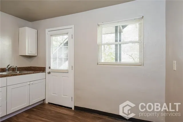 a view of a kitchen with wooden floor and a window