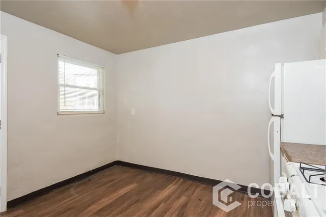 a view of a room with wooden floor and white walls