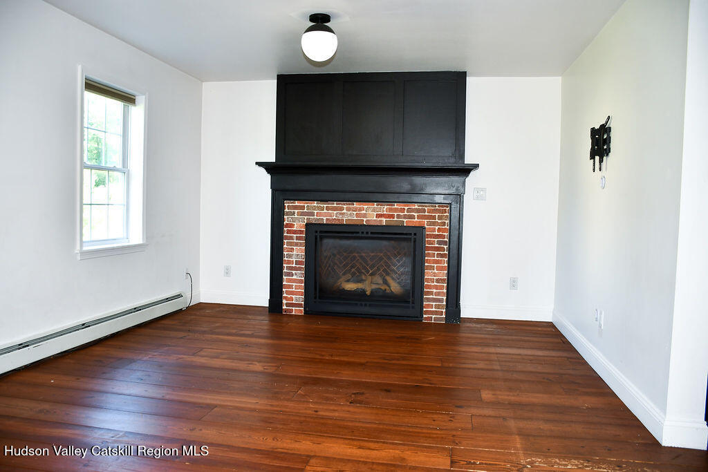 49 MacIntosh Drive Hudson, NY 12534 - Photo 11 of 39 a view of an empty room with wooden floor and a fireplace