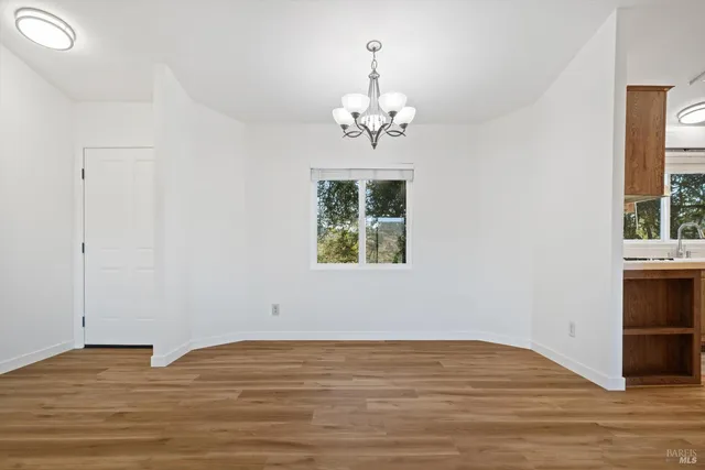 a view of empty room with window and wooden floor