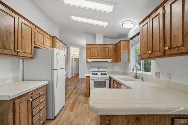 a kitchen with stainless steel appliances granite countertop a refrigerator a stove top oven a sink and dishwasher