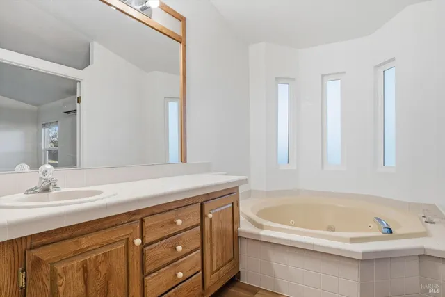a bathroom with a tub sink and mirror