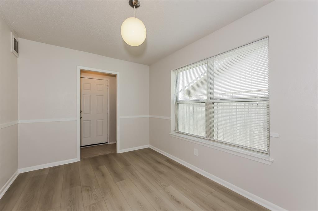 1816 Christopher Drive Fort Worth, TX 76140 - Photo 5 of 16 an empty room with wooden floor and windows