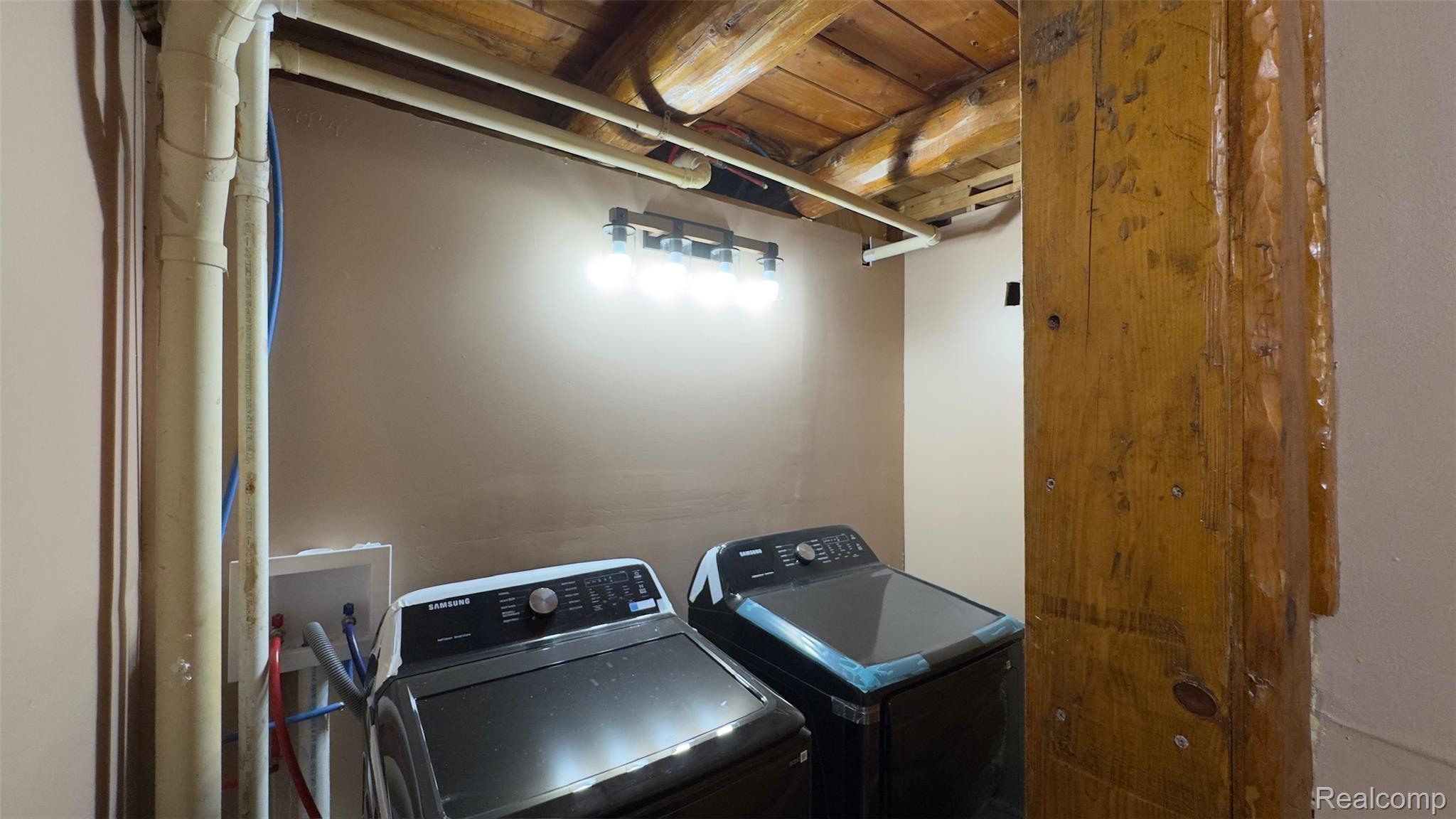 2608 East Sutton Road Metamora, MI 48455 - Photo 9 of 64 Laundry area featuring exposed wood ceiling beams and a large timber column