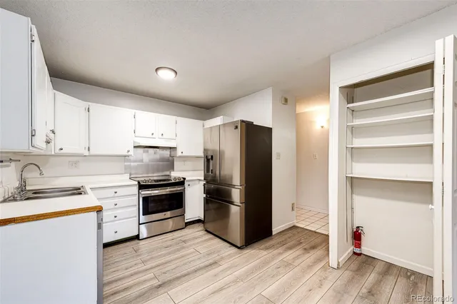 a kitchen with a refrigerator sink and cabinets