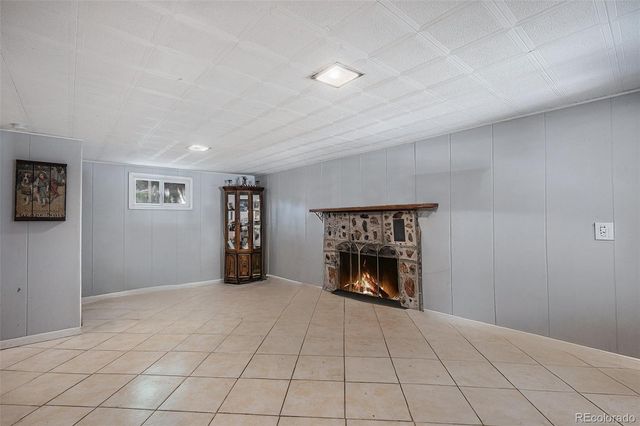 a view of an empty room with window and fire place
