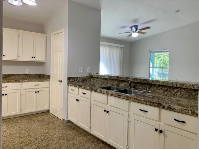 a kitchen with granite countertop a sink stainless steel appliances and cabinets