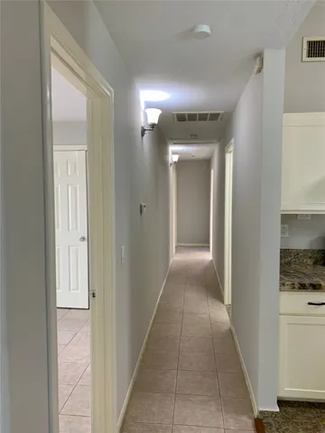 a view of hallway with shower and a sink