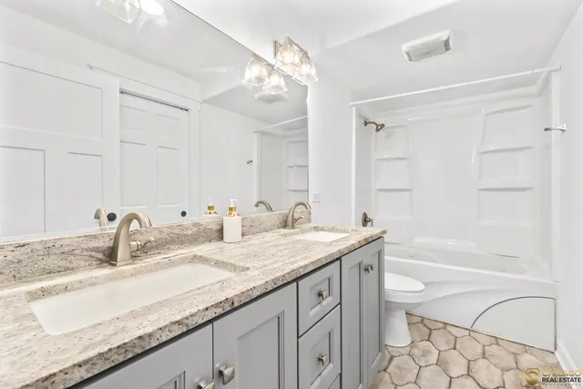 a bathroom with a granite countertop bathtub sink vanity and mirror