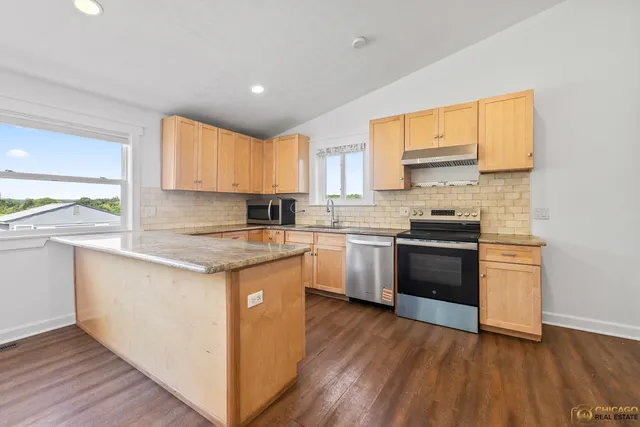 a kitchen with a sink a window and stainless steel appliances