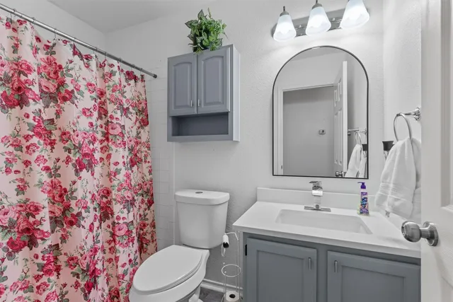 a bathroom with a sink and mirror with toilet