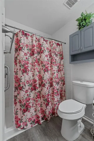 a white toilet sitting next to a shower curtain