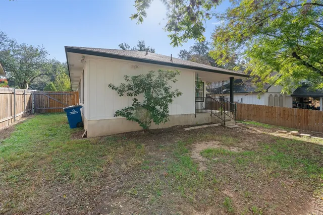 a view of a house with a backyard and a tree