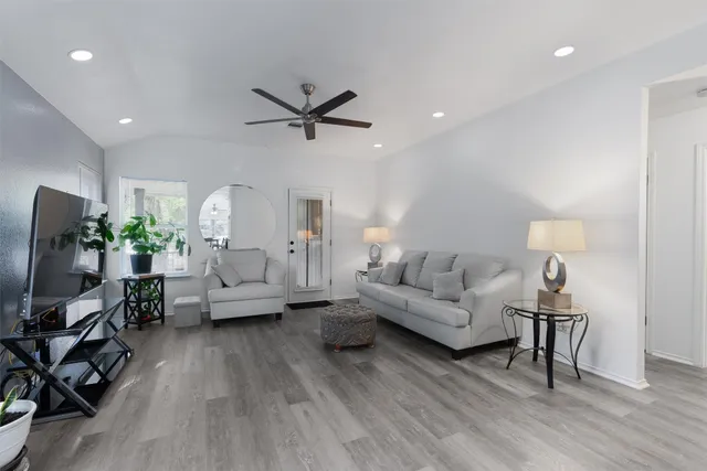 a living room with furniture and a wooden floor