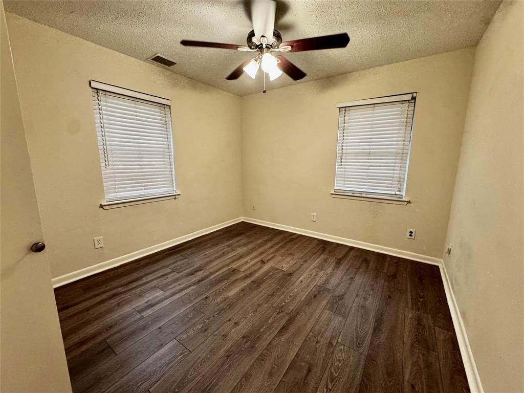 1706 Saddle Road Granbury, TX 76049 - Photo 11 of 29 a view of an empty room with wooden floor and a window