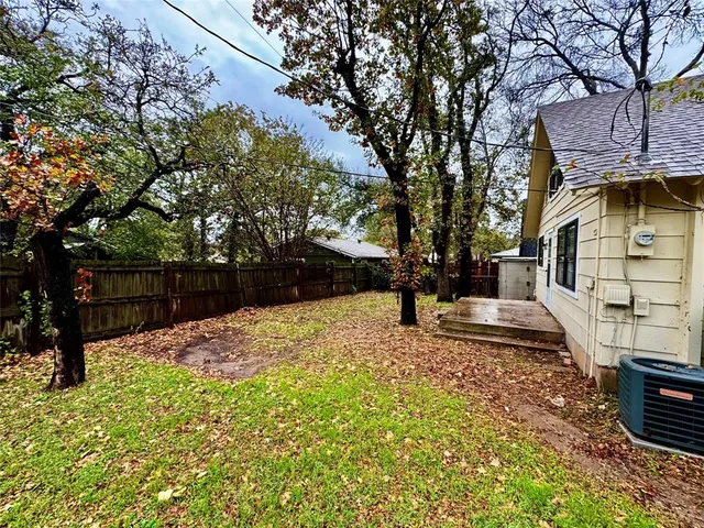 a view of a yard with wooden fence