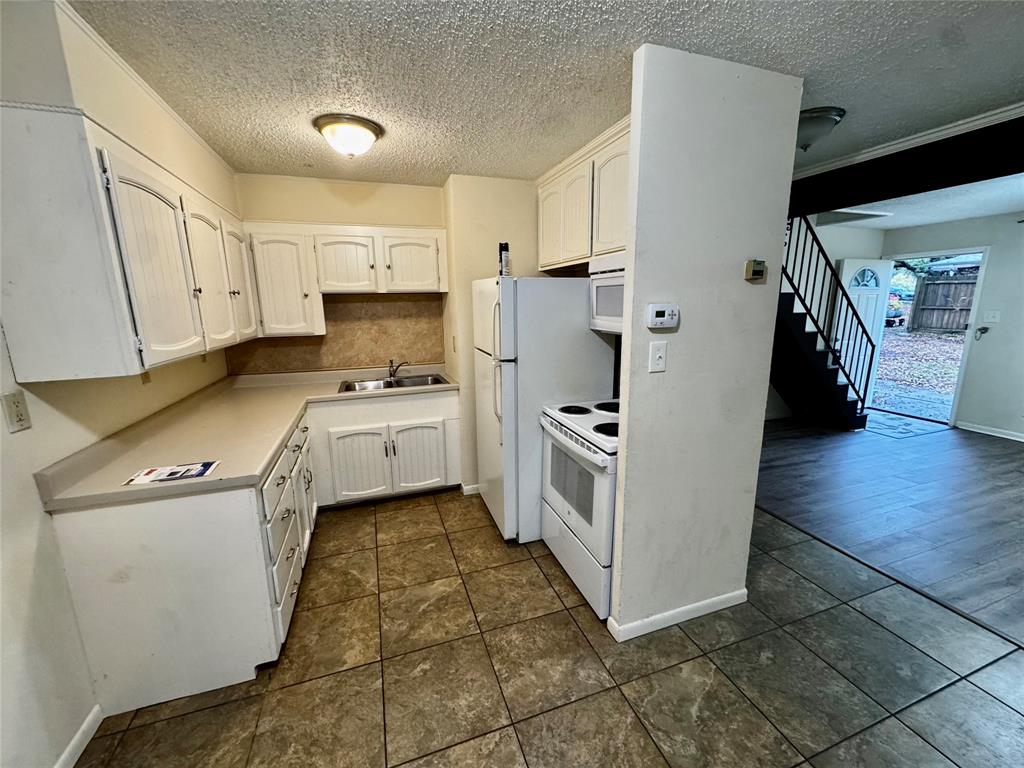 1706 Saddle Road Granbury, TX 76049 - Photo 8 of 29 a kitchen with a sink a stove top oven and cabinets