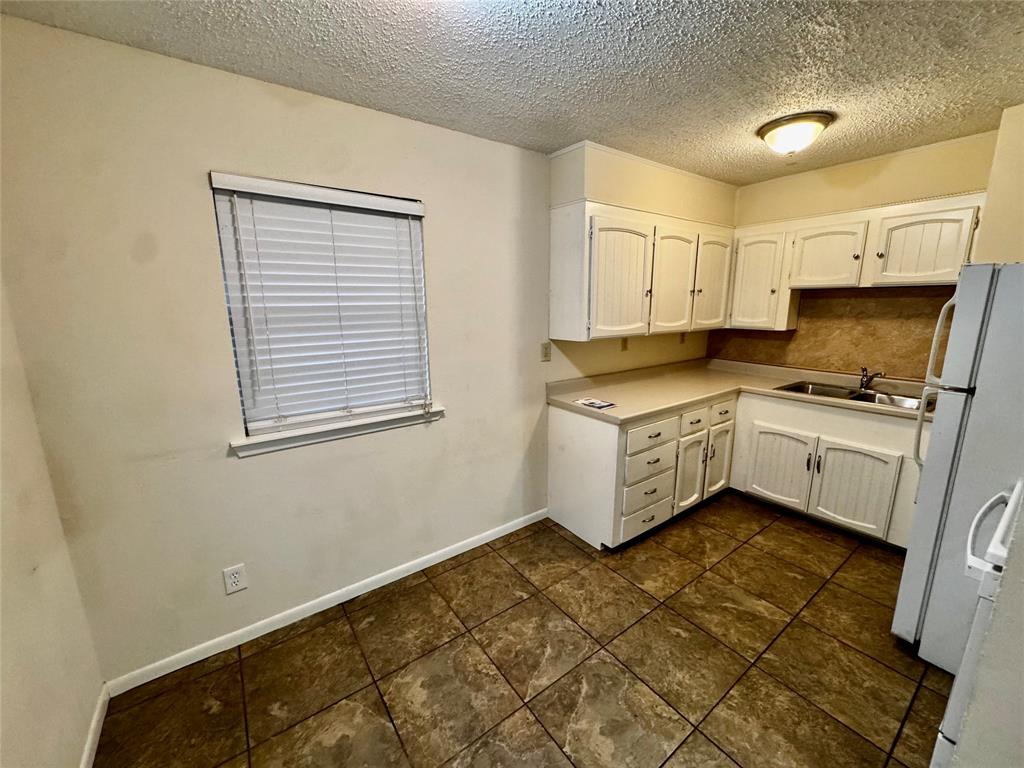 1706 Saddle Road Granbury, TX 76049 - Photo 9 of 29 a kitchen with a cabinets and white appliances