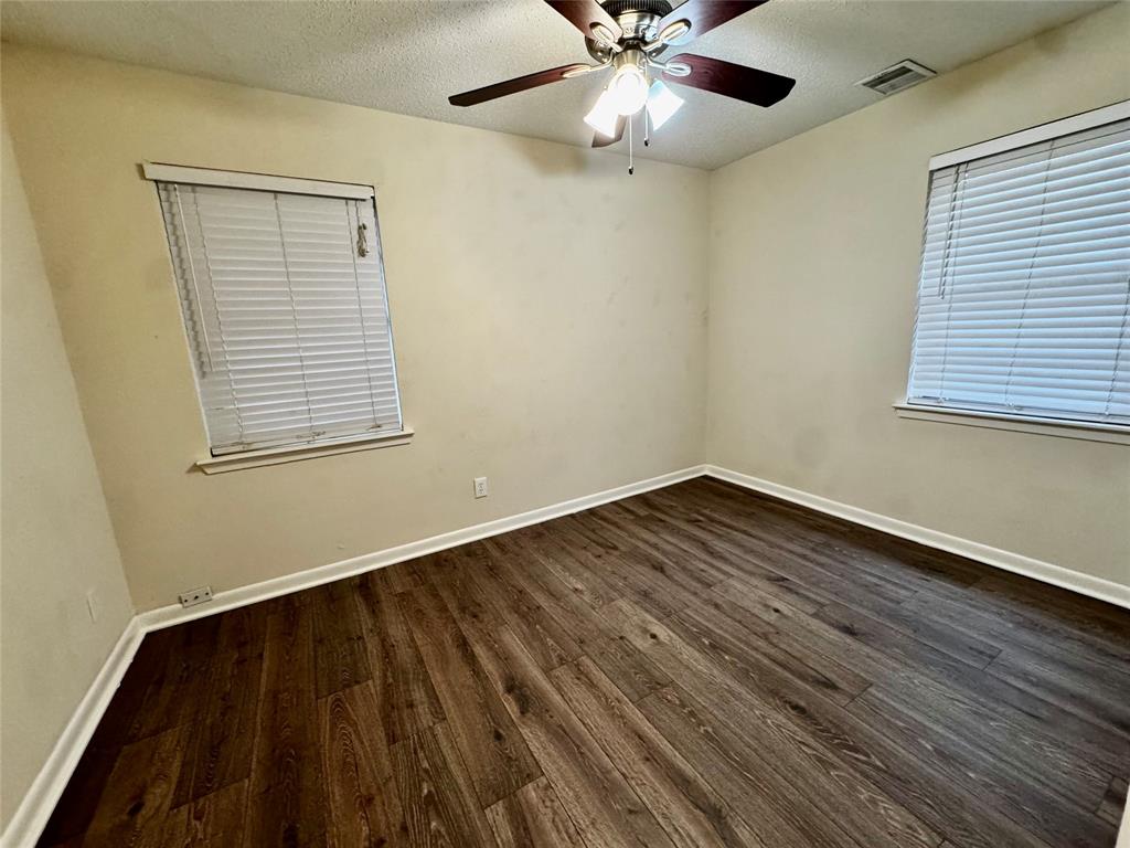 1706 Saddle Road Granbury, TX 76049 - Photo 10 of 29 a view of an empty room with wooden floor and a window