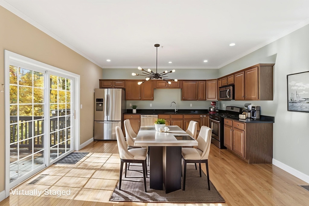 90 Rangeway Road, Unit 303 Billerica, MA 01862 - Photo 10 of 34 a kitchen with kitchen island granite countertop a sink cabinets and stainless steel appliances