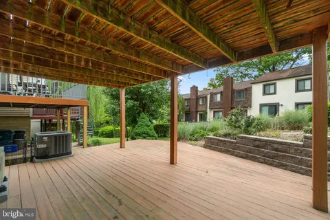 a view of a patio with table and chairs under an umbrella with wooden floor