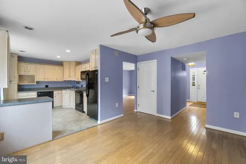 a view of a kitchen with kitchen island wooden floor and stainless steel appliances