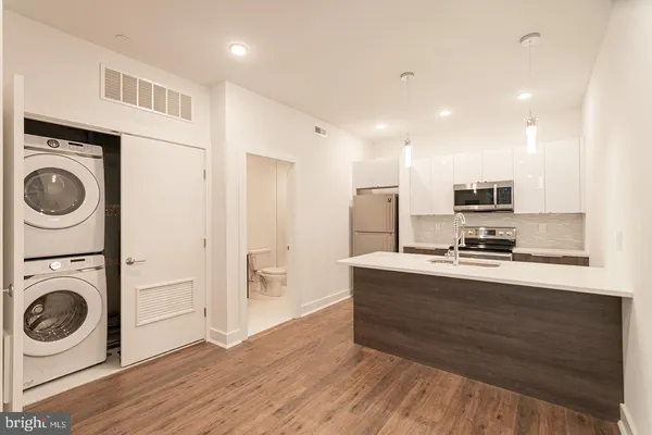 a large white kitchen with wooden floor