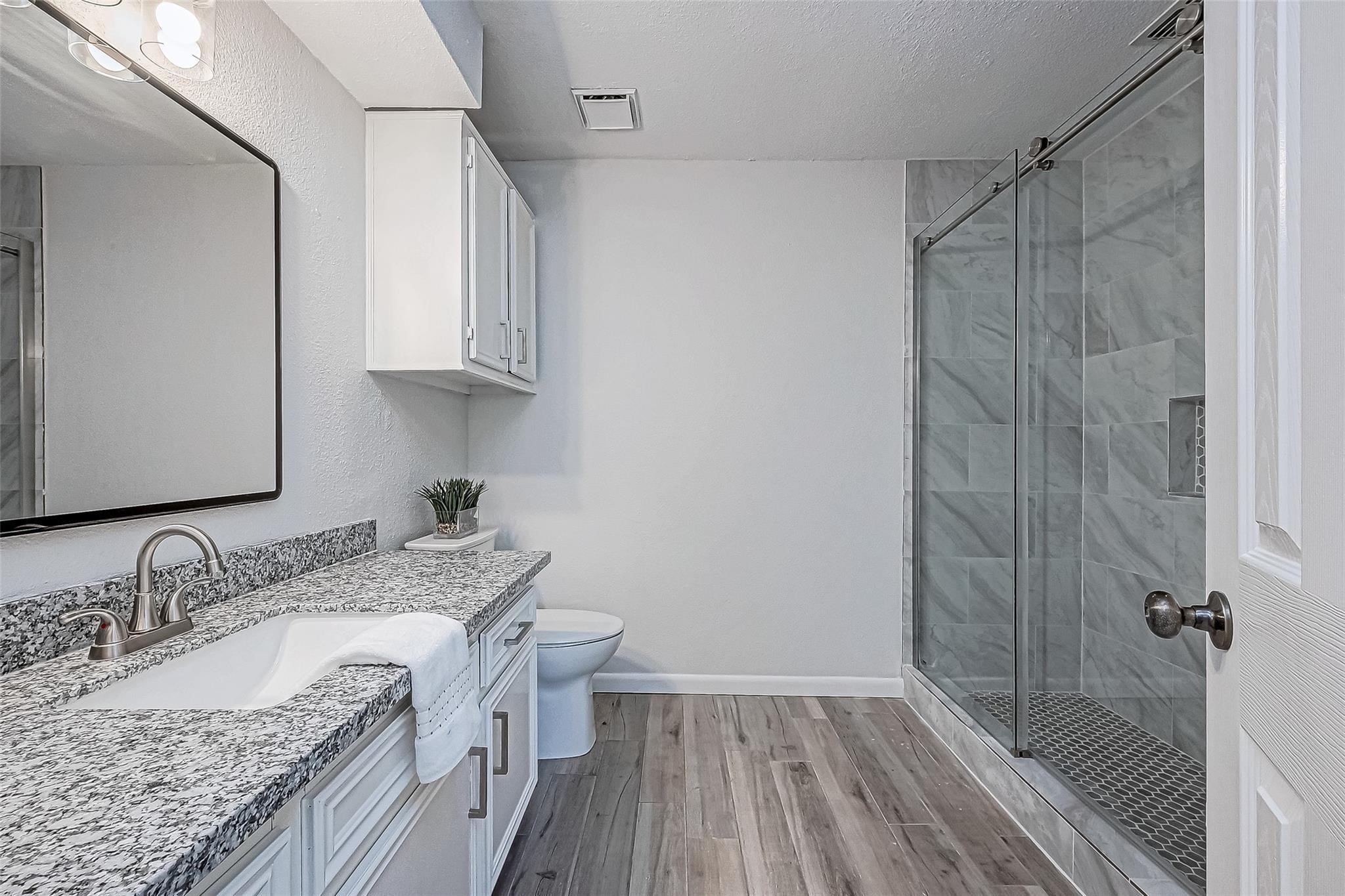 4907 Fox Hollow Boulevard Spring, TX 77389 - Photo 7 of 12 a bathroom with a granite countertop sink a mirror and shower