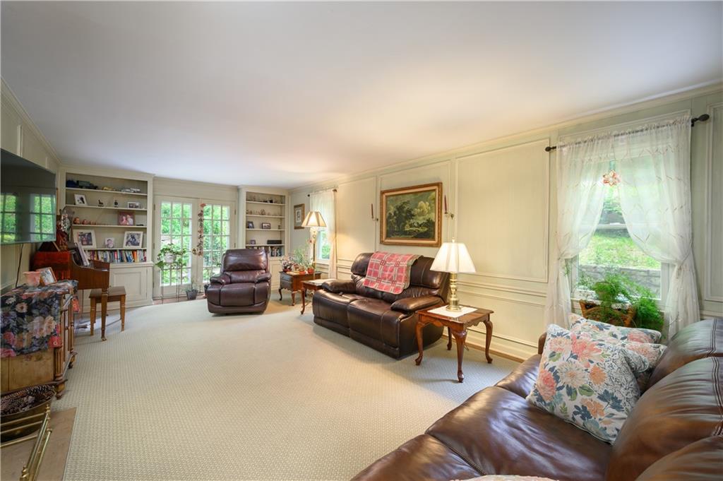 24 Myrtle Hill Road Sewickley, PA 15143 - Photo 5 of 21 Living room with French doors to back patio. Built in book classes. Paneling.