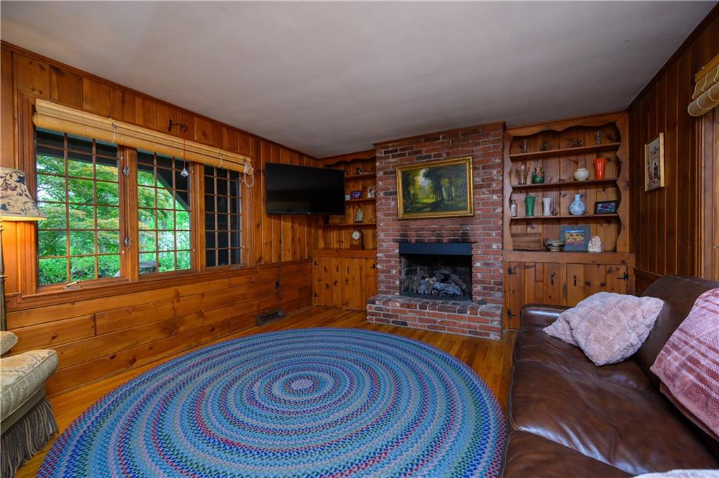 24 Myrtle Hill Road Sewickley, PA 15143 - Photo 9 of 21 Family room with fireplace. Pine paneling. Built in book cases. Hardwood floors.