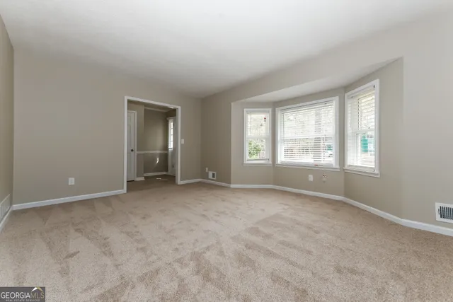 an empty room with windows and closet