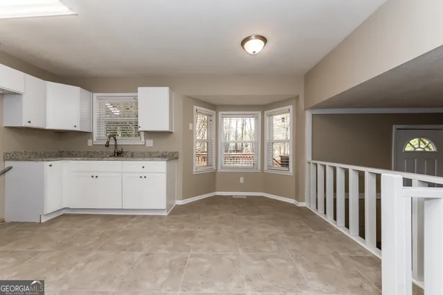 a kitchen with granite countertop a sink and cabinets