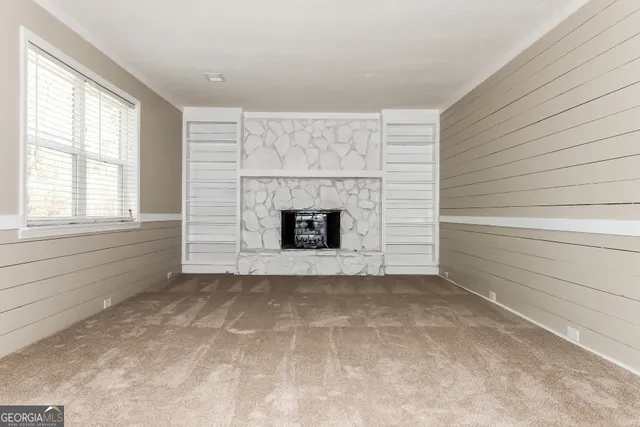 a view of an empty room with a fireplace and a window