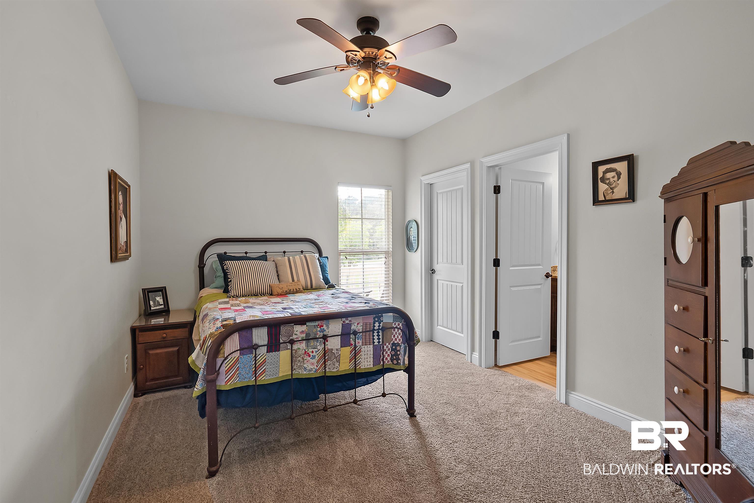 12070 Comalander Road Fairhope, AL 36532 - Photo 26 of 50 Carpeted interior room featuring a ceiling fan with light kit, a window with blinds, and white interior doors with black hardware