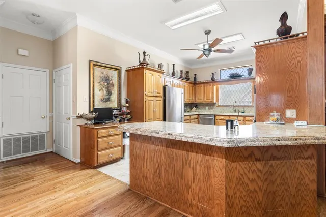 a kitchen with granite countertop a refrigerator and cabinets
