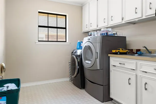 a kitchen with stainless steel appliances cabinets and a chandelier